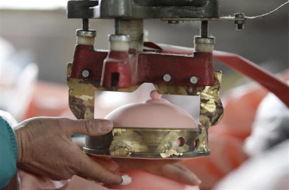 A worker puts on a breast for an inflatable sex doll at Ningbo Yamei plastic toy factory