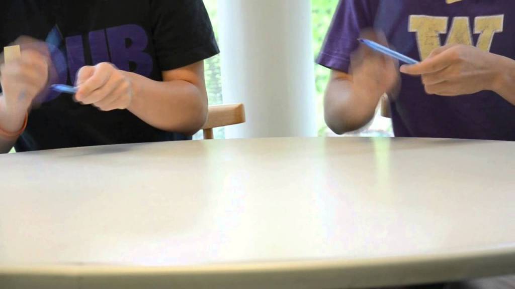 Two Students Create Music by Skillfully Drumming on a Table With Pens