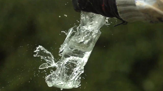 Super Slow Motion Video of a Man Breaking the Bottom Out of a Beer Bottle With the Palm of His Hand