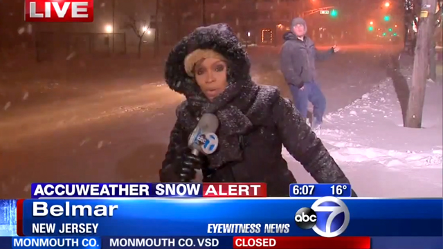 Guy Shreds on His Air Guitar Behind TV News Reporter During a Snowy Weather Alert