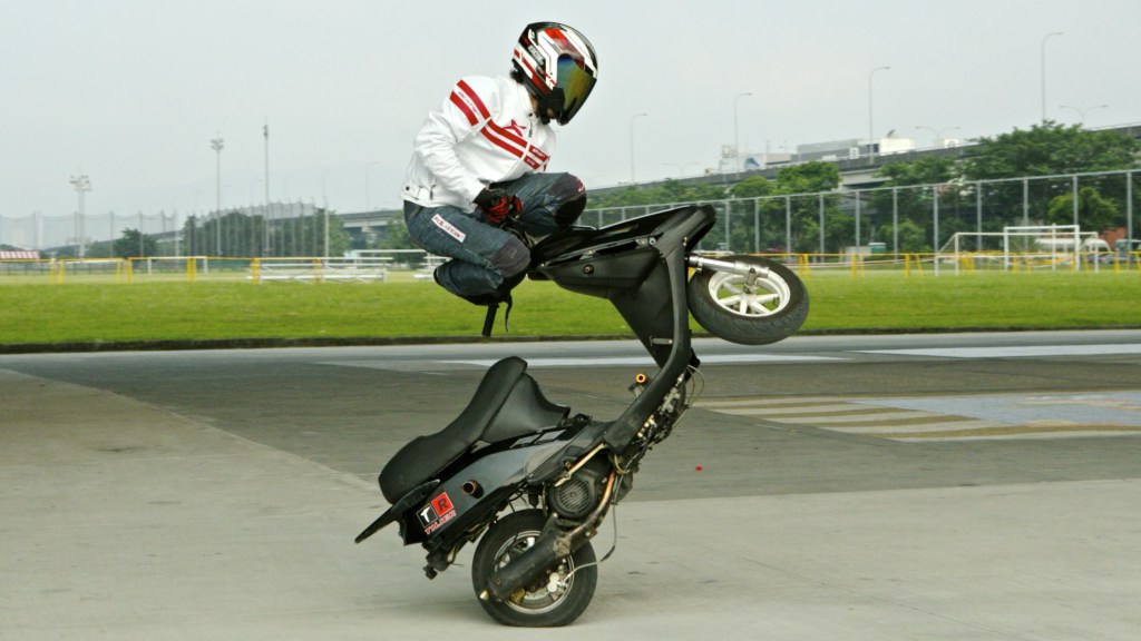 A Stunt Rider Performs a Series of Impressive Freestyle Tricks on a Scooter