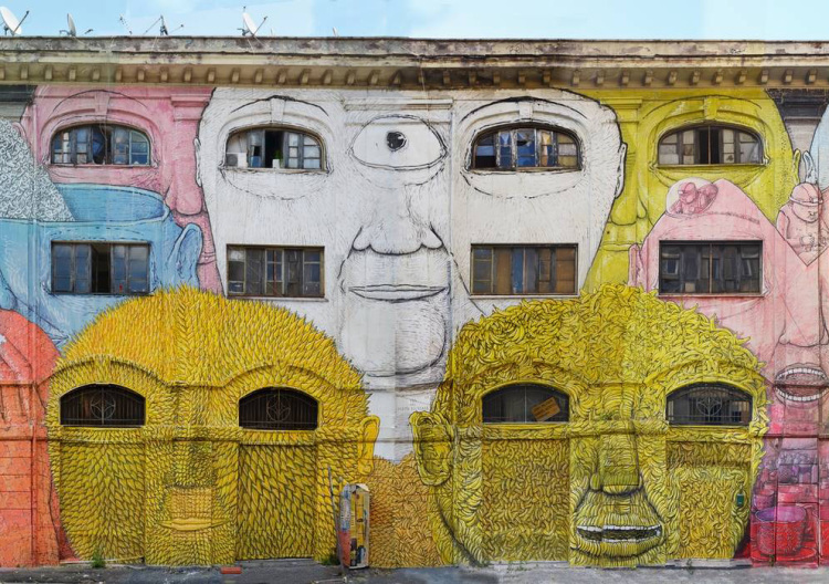 Italian Street Artist BLU Covers Two Sides of a Warehouse in Rome With Colorful Faces