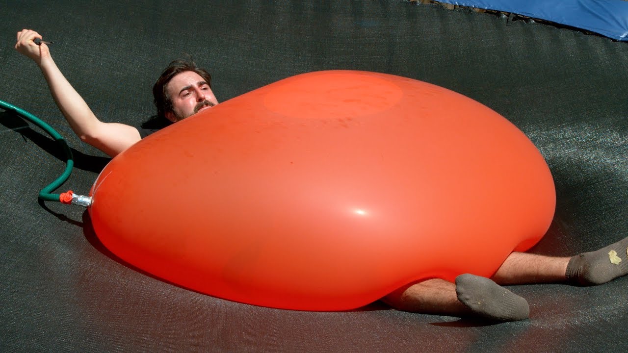 Dan Gruchy of The Slow Mo Guys Pops a Gigantic 6 Foot Water Balloon That Is  Crushing Him