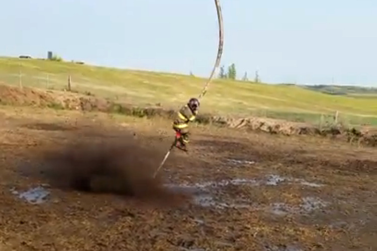 A Daring Firefighter Holds on Tight to a Powerful Fire Hose While Being Whipped Around a Mud Pit2