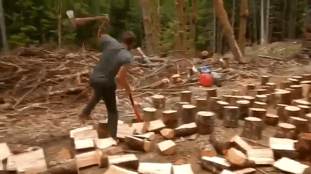 An Ambitious Man Splits Logs Very Quickly With Two Axes