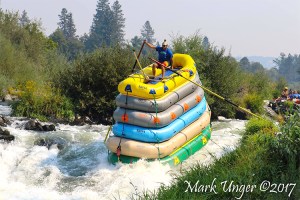 Daring Man Rides Down Class 4 Rapids On Top of 6 Rafts That Are Strapped Together