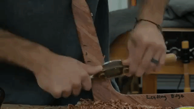 A Man Carves a Boomerang Out of a Tropical Wood From Brazil