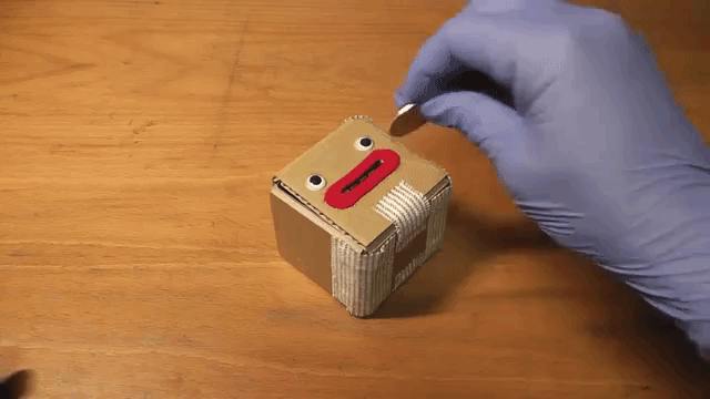 A Cute Cardboard Coin Box That Blasts Open When Money Is Put Into Its Mouth