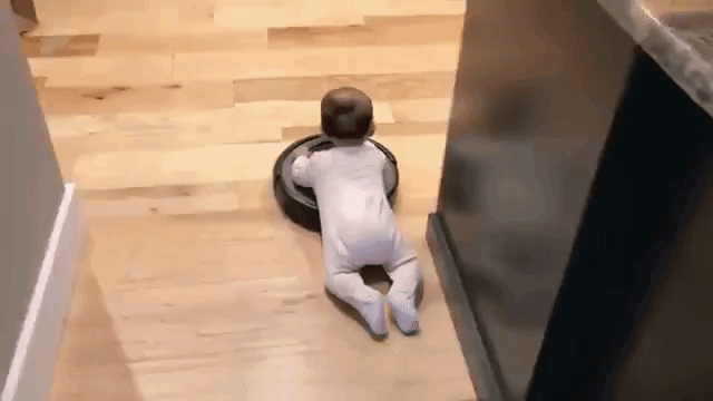 Cute Baby Hangs Onto a Roomba to Take a Ride Around the Kitchen