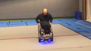 A Man Rides Around on His Wheelchair That Is Mounted On Top of a Hoverboard
