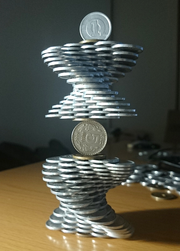 A Man With a Steady Hand Stacks Coins to Create Gravity Defying Sculptures