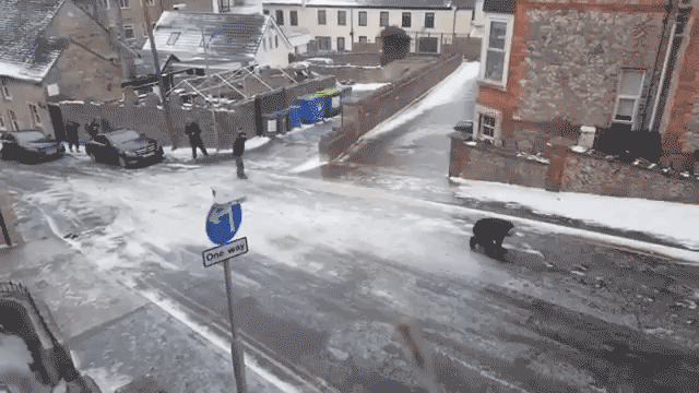 People Unsuccessfully Try to Walk up an Icy Hill in Swanage, England