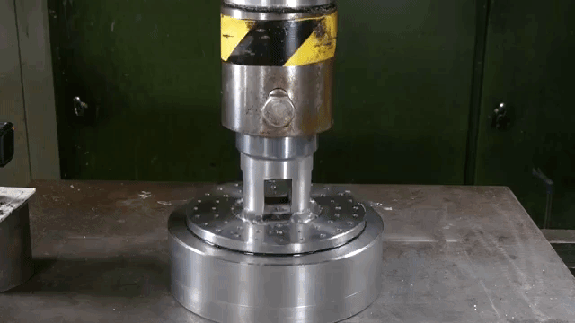 Non-Newtonian Fluid Being Pushed Through Small Holes With a Hydraulic Press