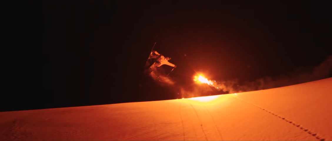 Nighttime Skiing Lit by Red Flares