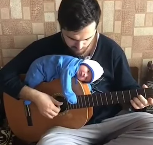 Baby Lies on Top of Guitar While Dad Strums