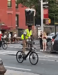 Man Rides Bicycle with Trash Can on His Head