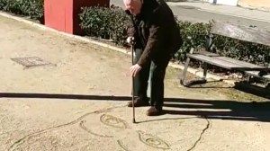 Man Draws Faces With Cane