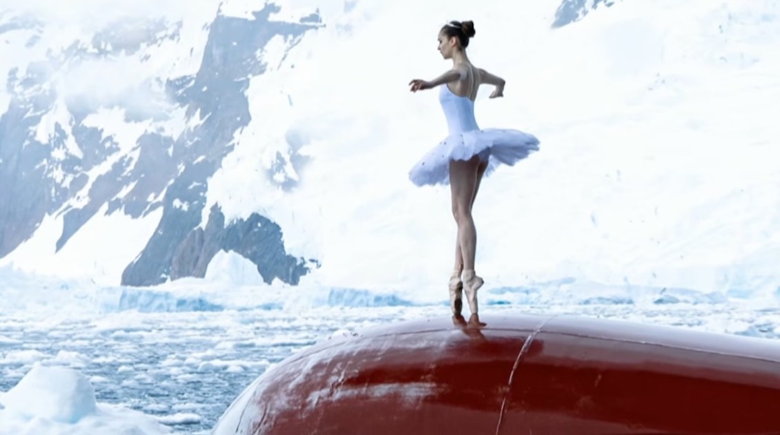 Brave Ballerina Dances En Pointe on the Bow of a Ship Traversing the Icy Antarctic Ocean