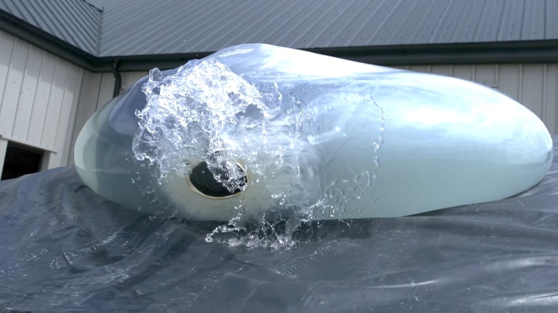 Slow-Motion Footage of Man Inside a Water Balloon Rolling Down a Ramp