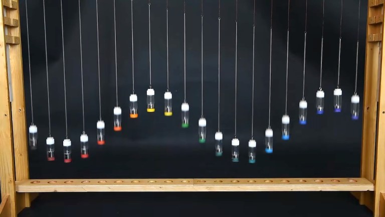 Twenty mercury-filled vials suspended from springs forming a wave pattern