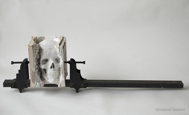 Incarnate, a Human Skull Carved Into Old Software Manuals by Maskull Lasserre