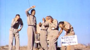 5 volunteers standing under an Aerial Nuclear Test